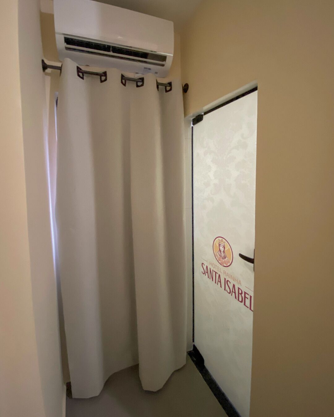 A hotel room with a sliding door marked "HOTEL SANTA ISABEL".