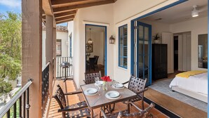 Un balcón con mesa lista para comer, una cama y vistas al exterior.