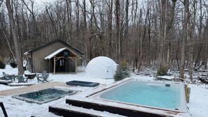 A hot tub and a sauna in a snowy outdoor setting with a wooden deck and a small shed in the background. - Sugar Creek Cabin w/ Nordic spa bordering 2 state parks! (Waveland)