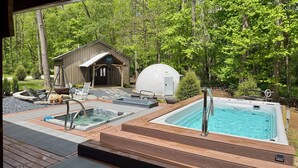 A hot tub and a sauna area with a wooden deck, surrounded by a forest. - Sugar Creek Cabin w/ Nordic spa bordering 2 state parks! (Waveland)