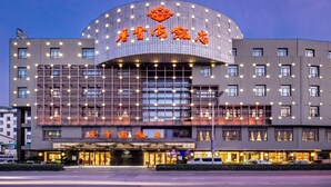 A hotel with a modern design, featuring a curved facade and multiple windows. - Xiangxuehai Hotel (Suzhou)