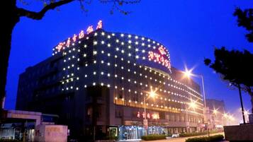 A multi-story building with illuminated signage and a curved facade.