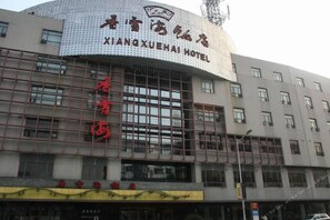 A hotel building with a prominent sign reading 'XIANQXUEHAI HOTEL' and a large window display. - Xiangxuehai Hotel (Suzhou)