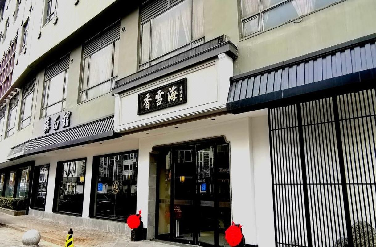 A hotel facade with signage, large windows, and a gated entrance.