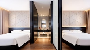 A hotel room with two beds, a bench, a mirror, and a small table. - Xiangxuehai Hotel (Suzhou)