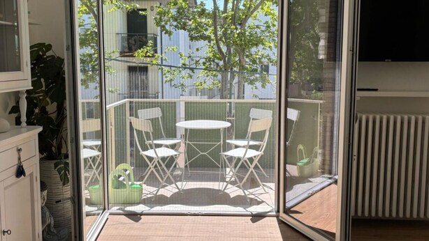 Un balcon avec une table et des chaises, une vue sur la ville et un radiateur.