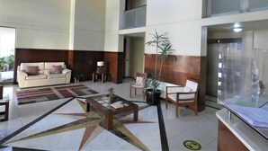 A spacious lobby with a high ceiling, a central coffee table, a sofa, and a potted plant. - Special for business, 2 blocks from the subway! (Ñuñoa)