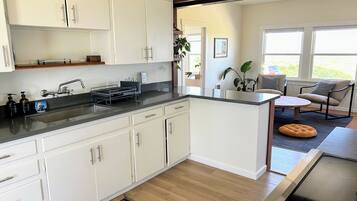 Enjoy a clean and contemporary kitchen with sleek cabinetry, a stove, and a cozy seating area.