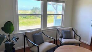 A room with two chairs facing a large window overlooking a grassy area.