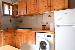 Frigorífic, forn, rentaplats i una taula de menjador 