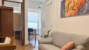 Ein Wohnzimmer mit einer Couch, einem Tisch und einem Bild an der Wand.