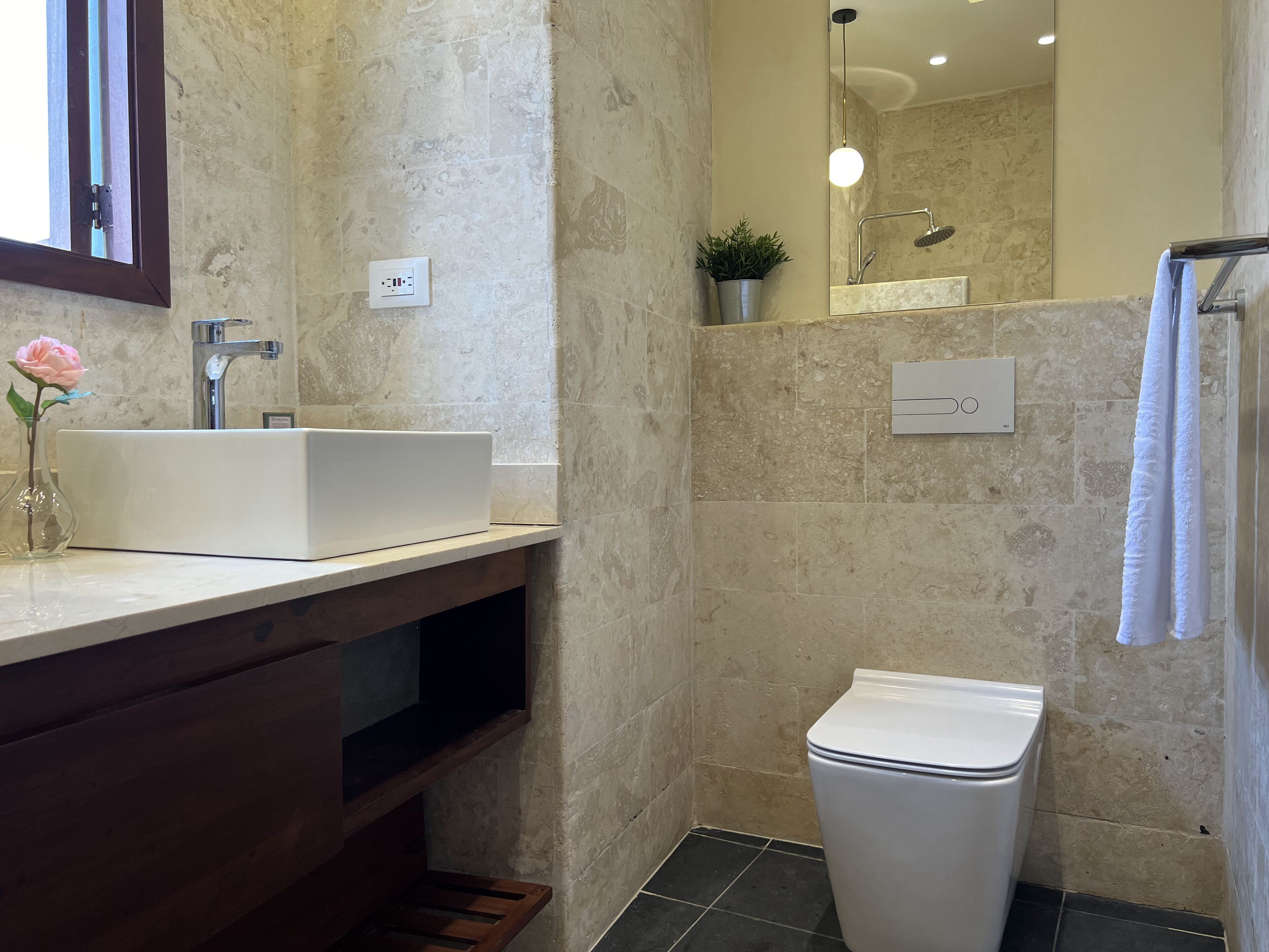 A bathroom with a white sink, a toilet, and a shower area.