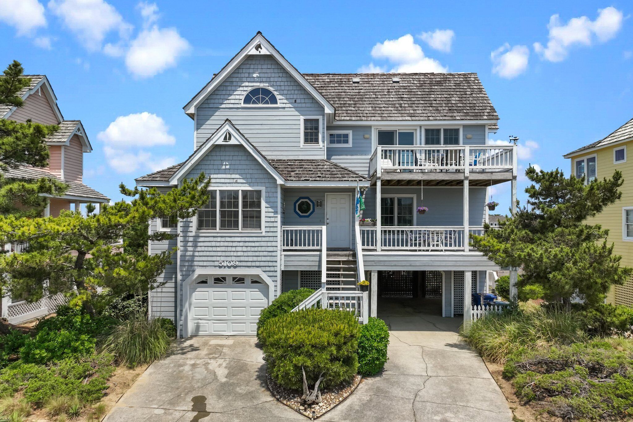 A two-story house with a front porch, a garage, and a balcony.