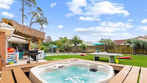 A backyard with a hot tub, a barbecue area, and a pool table. - Tropical Feel, Heated Pool, Hot Tub, Game Room, Mini Golf (Panama city beach)