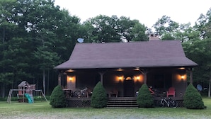 A rustic cabin with a porch, surrounded by a gravel driveway and a grassy area. - Clearfield Co Rockton PA - Cabin Escape (Rockton)
