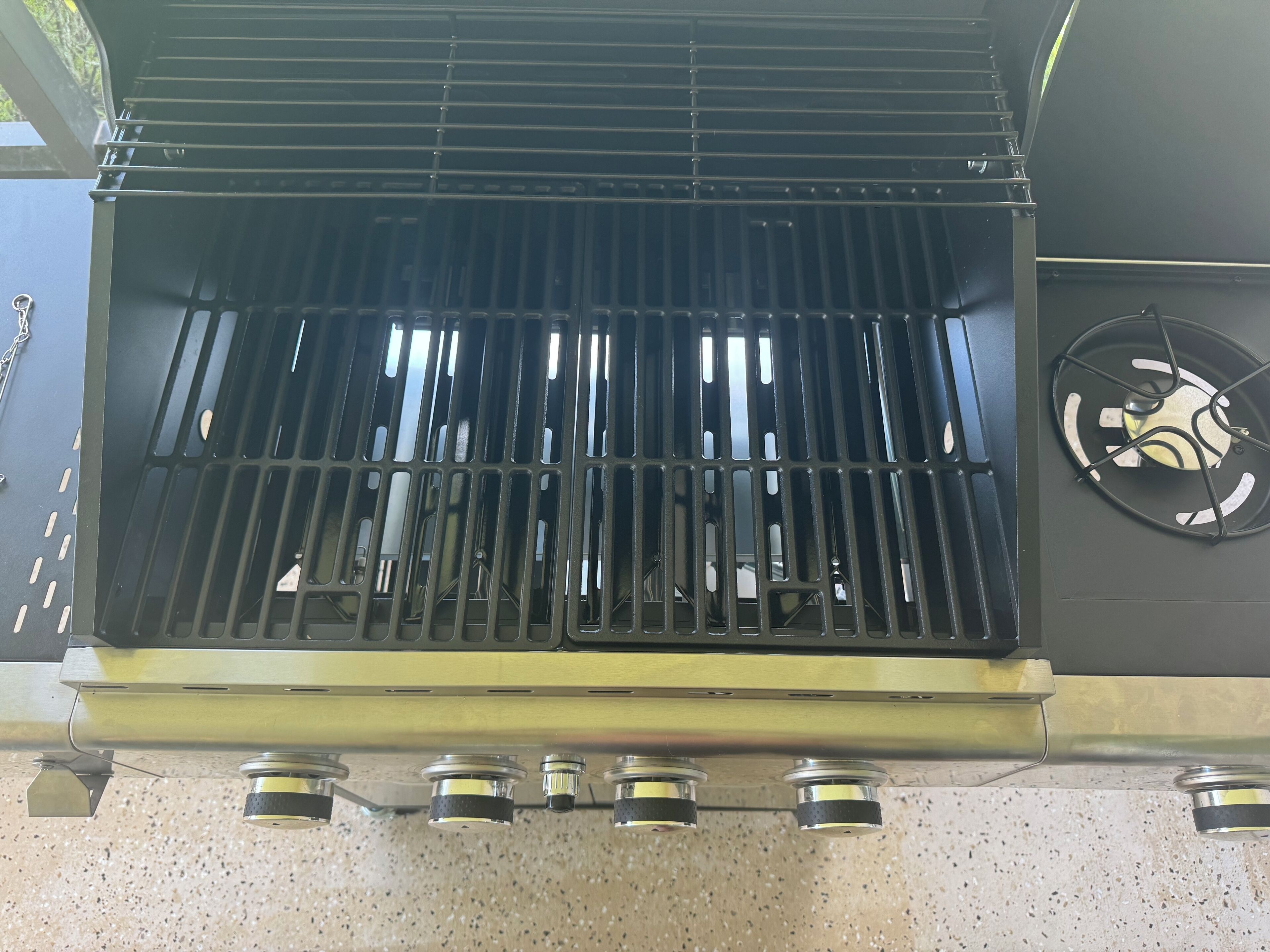 A grill with a metal grate and a fan on the right side.