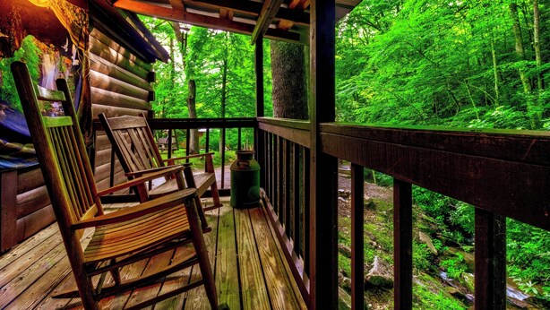 Eine Holzterrasse mit Blick auf einen Wald.