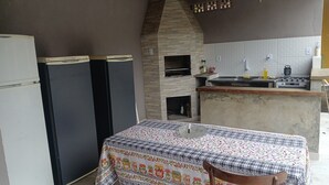 Eine kleine Küche mit einem Steinkamin, einem Spülbecken und einem Tisch mit gemustertem Tischlauf.