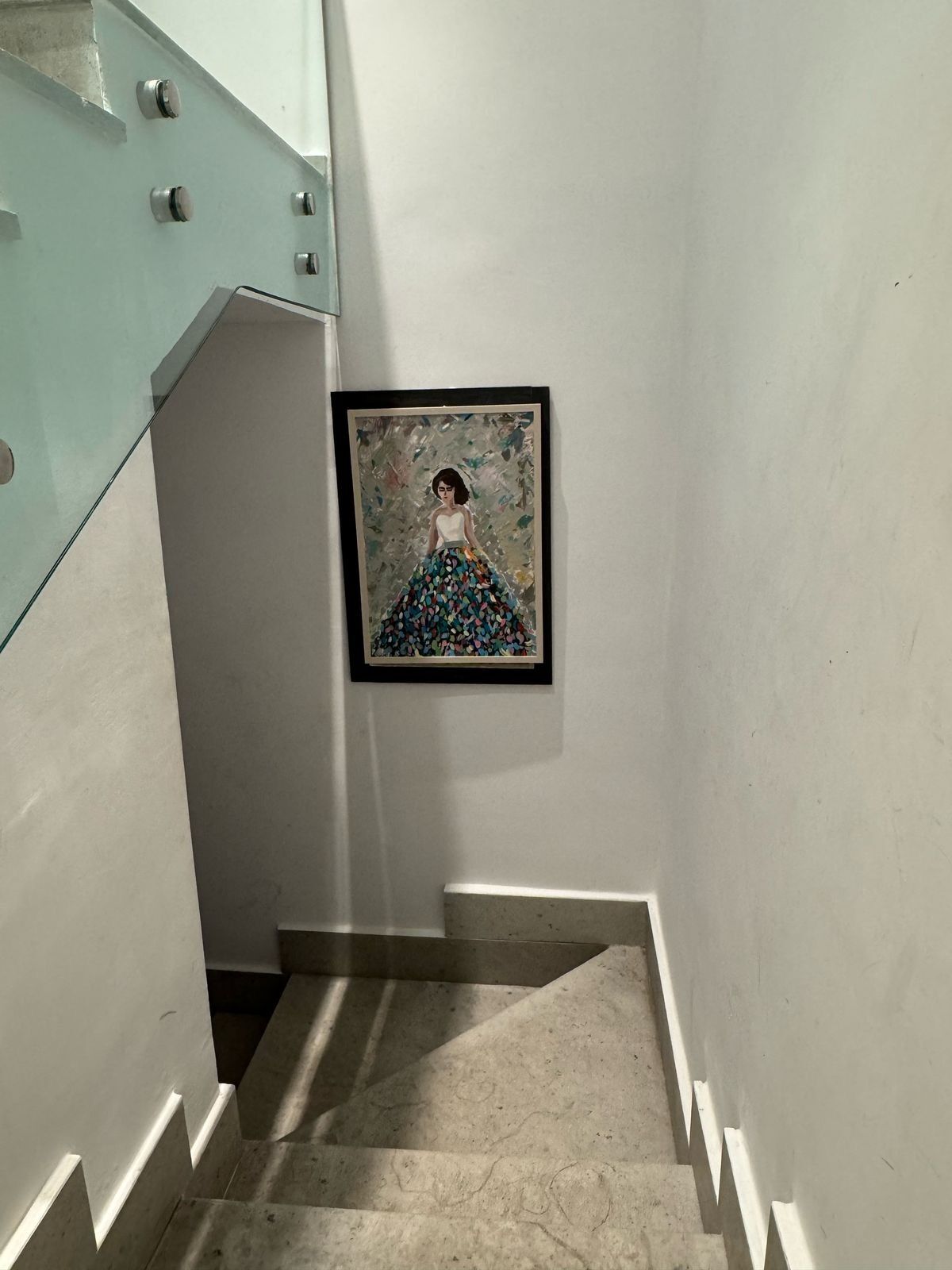Uma escadaria com uma obra de arte emoldurada na parede.