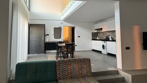 A modern apartment with a dining area, kitchen, and a large window. - Blue Lagoon duplex with views of cape blanc, sea 🌊, grotto beach and forest🌳 (Bizerte)