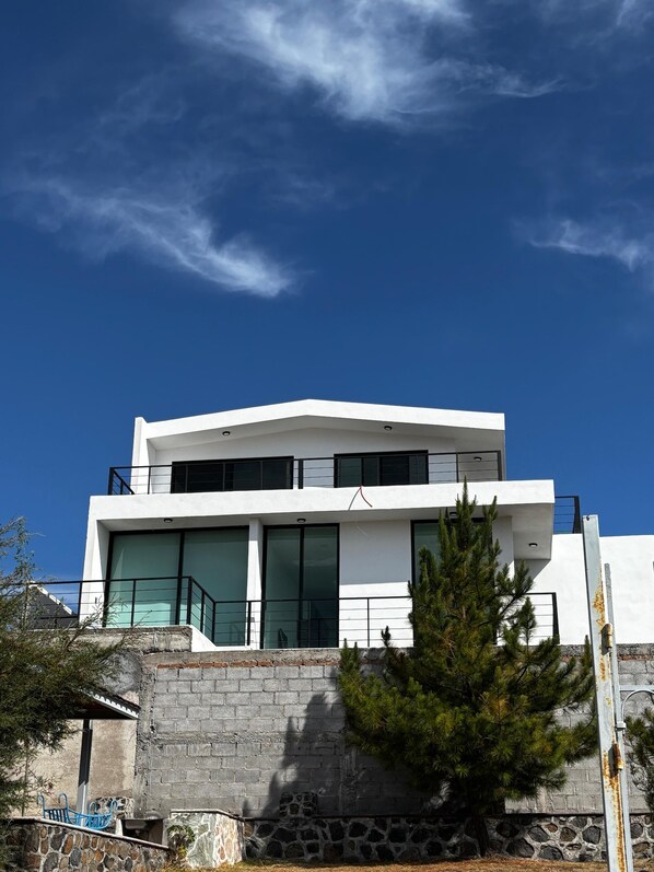 Un edificio moderno de dos pisos, con amplios ventanales y cimientos de piedra.
