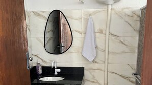 Een badkamer met een zwarte wastafel, een wit toilet en een spiegel.