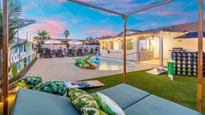 A backyard with a pool, outdoor seating, and a covered patio area. - INSTAGRAMABLE AZ retreat W pool, game room, BBQ, room for the whole crew & more! (Phoenix)