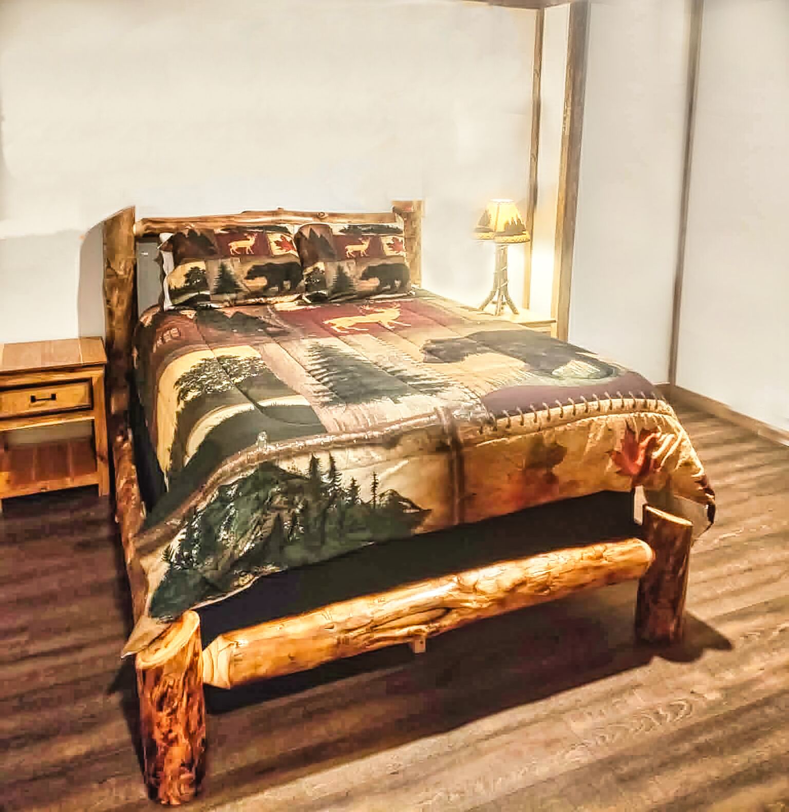 A bed with a patterned bedspread and a wooden headboard.