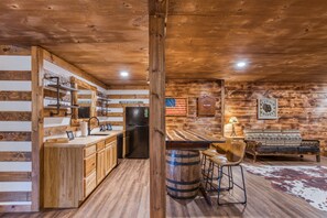 Een knus chaletinterieur met keuken, bar en zithoek.
