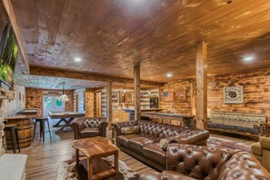 Een rustiek interieur met houten plafond, lederen meubels en een bar.