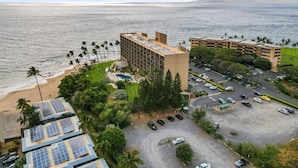 A hotel with a pool, solar panels, and a view of the ocean.