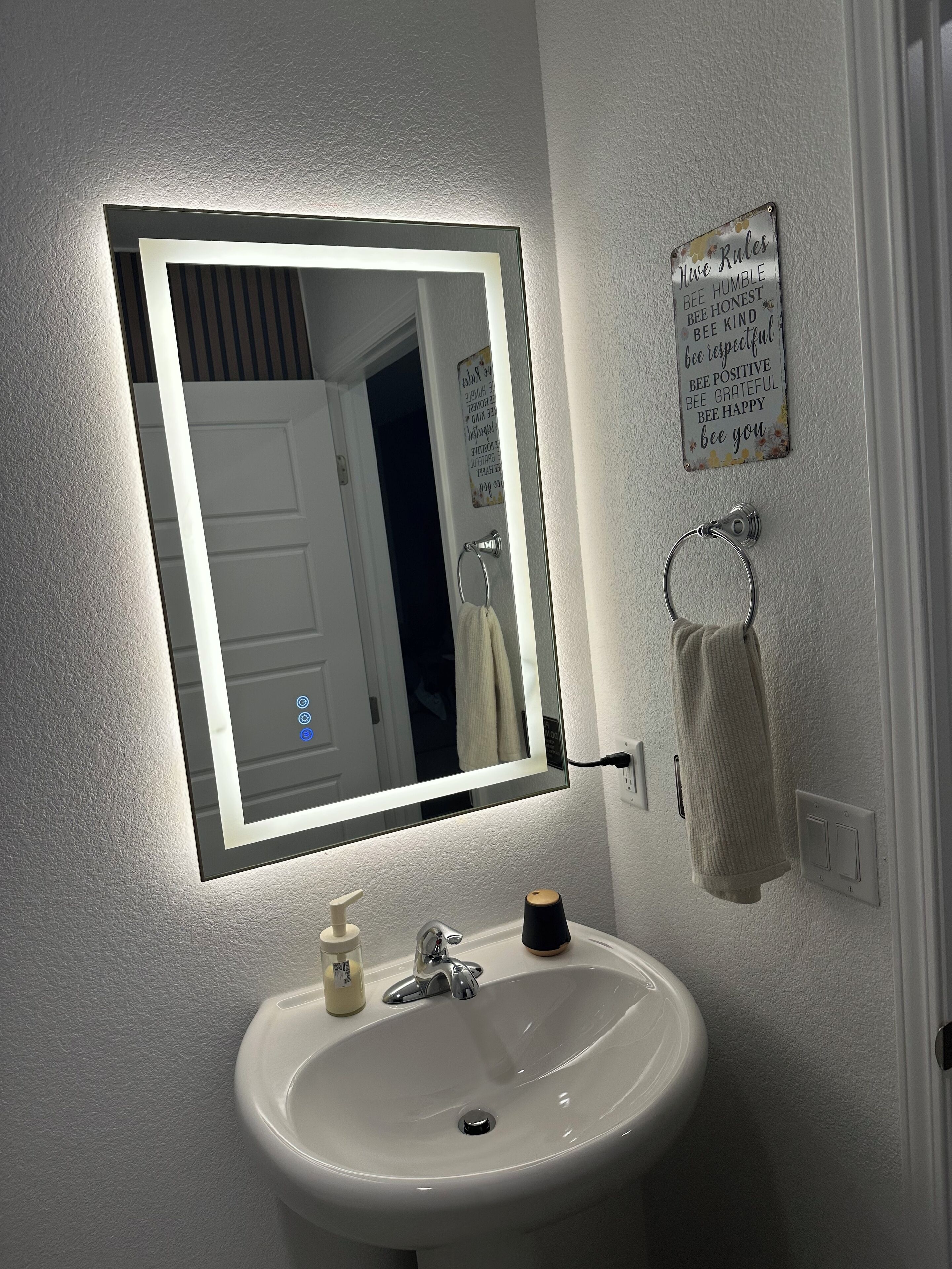 A bathroom with a white sink, a mirror, and a towel rack.