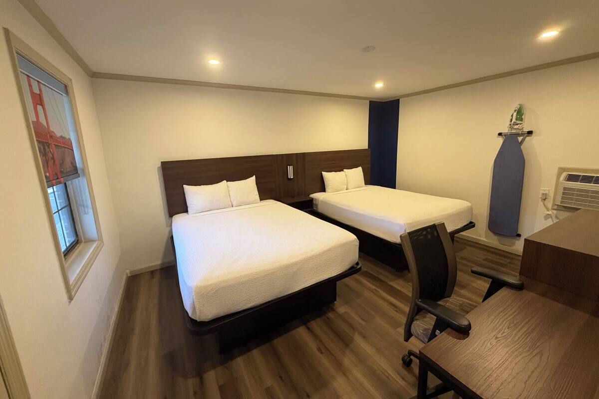 Una habitación de hotel con dos camas, un escritorio y una silla.