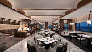 Un restaurant moderne doté d’une grande salle à manger, de nombreuses tables et d’un bar offrant une vue sur la ville.