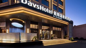 L’entrée d’un hôtel, avec une grande enseigne indiquant « DaysHotel » et « By Wyndham ».
