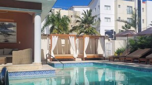 A pool area with a cabana, lounge chairs, and a view of the hotel buildings. - Villa Mare B3 (on the beach Bavaro) Los Corales (Punta Cana)