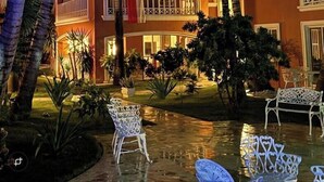 A multi-story hotel with balconies, palm trees, and outdoor seating. - Villa Mare B3 (on the beach Bavaro) Los Corales (Punta Cana)
