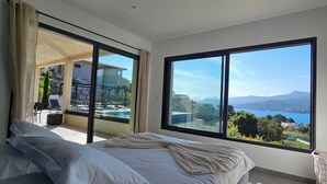 A bedroom with a large window offering a view of a lake and mountains. - Villa Haut Standing Stella Di Mare panoramic view (Propriano)
