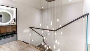 A modern staircase with a glass railing and hanging pendant lights. - Gorgeous 4 Bedroom Ski In/out Condo in Beaver Creek Village (Avon)