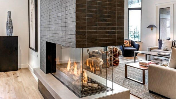 A modern living room with a glass fireplace, a sofa, a coffee table, and a fireplace mantel. - Gorgeous 4 Bedroom Ski In/out Condo in Beaver Creek Village (Avon)
