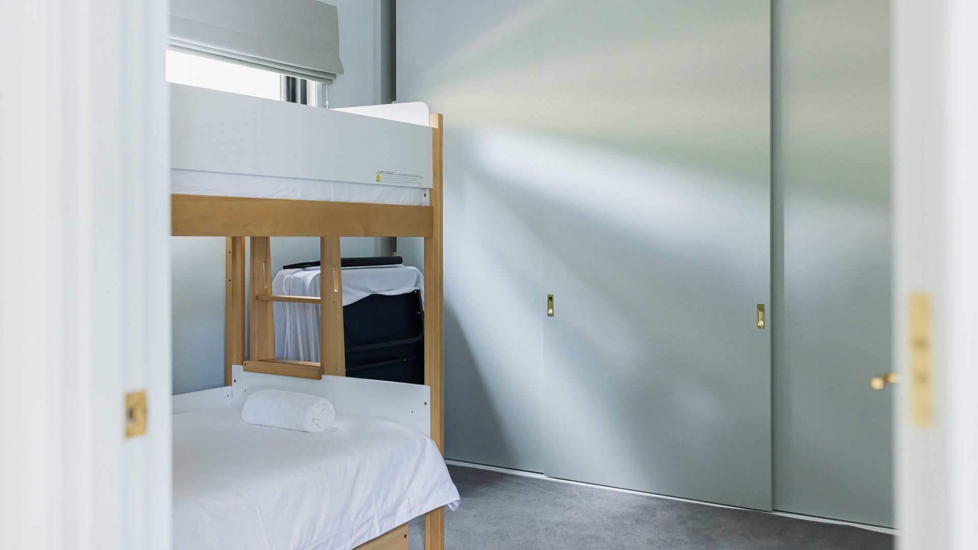 Habitación con literas, un armario y una ventana.
