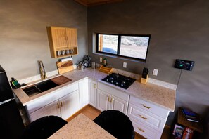 Una cocina compacta con un fregadero, estufa y armarios de madera.