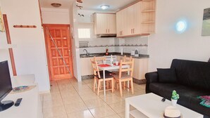 A compact living space with a kitchenette, a dining area, and a seating area with a couch. - Los Angeles 1 bedroom pool view 520 (ARONA)