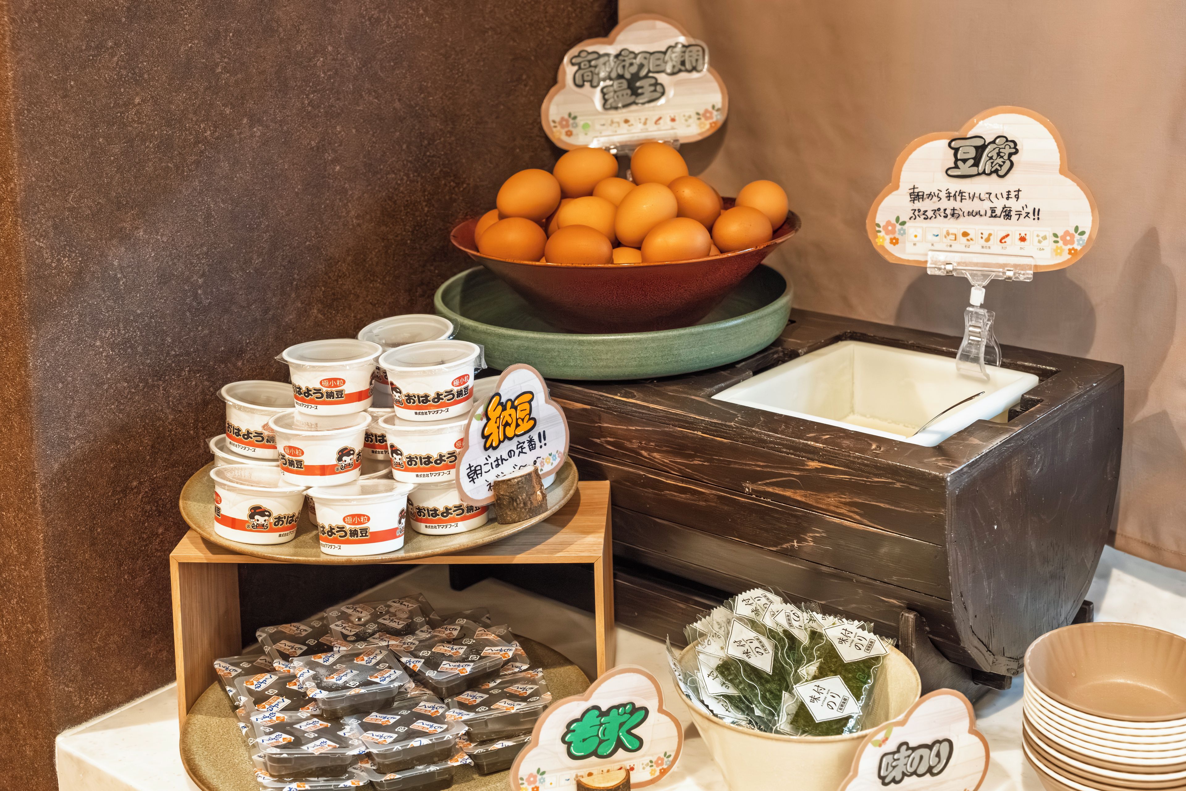 A display of food items including a bowl of eggs, packaged snacks, and a water dispenser.