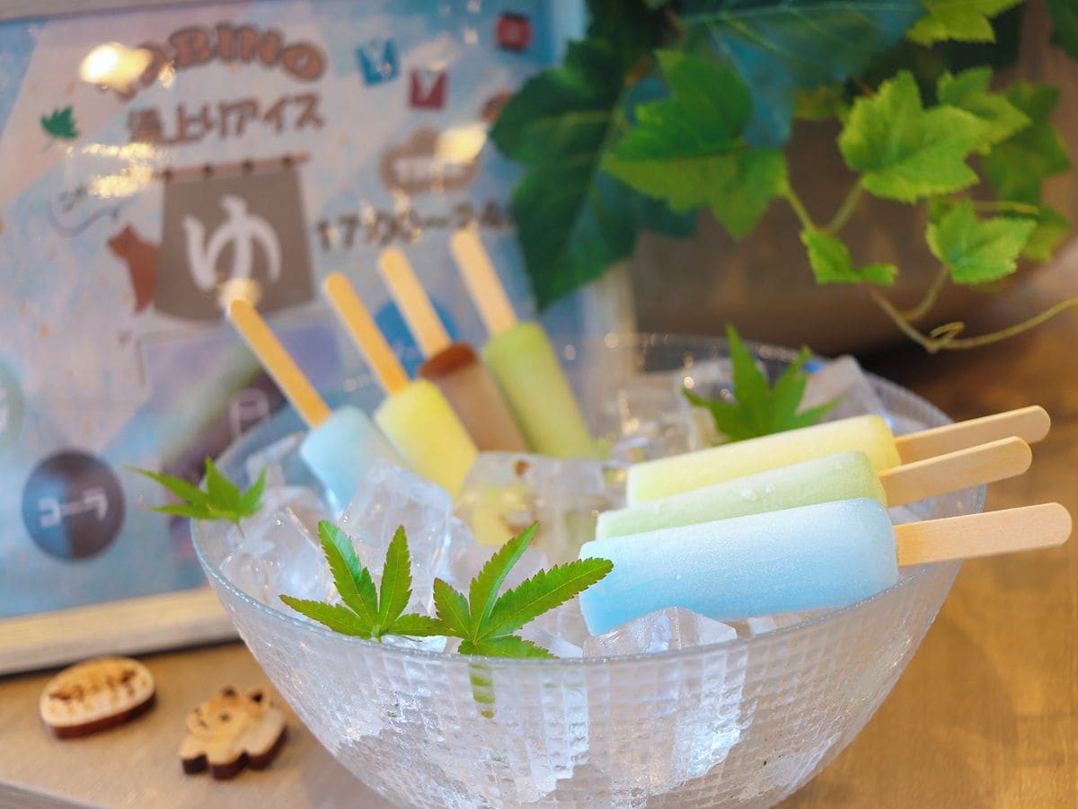 A bowl of ice with popsicles and mint leaves.