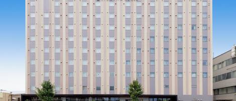 Un hôtel à plusieurs étages doté d’une façade moderne, avec un logo bien visible sur le dessus.