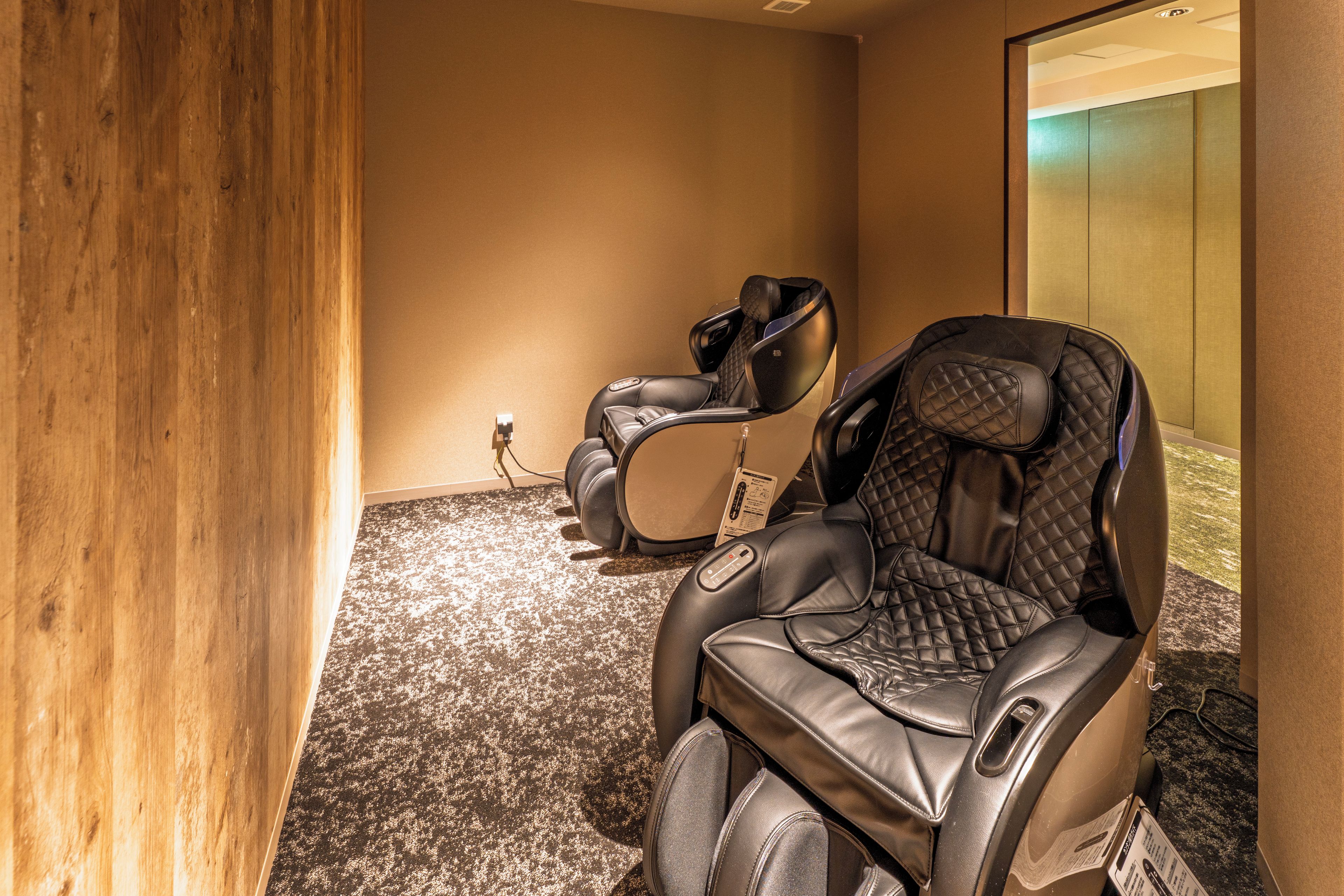A massage chair in a room with a wooden accent wall and carpeted floor.