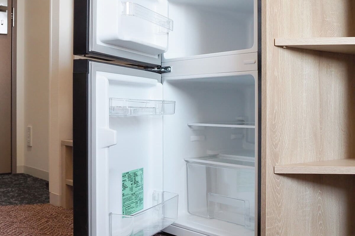 Un réfrigérateur moderne et vide, doté de plusieurs compartiments et d’un congélateur intégré.