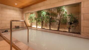 A spa area with a glass wall, a wooden ceiling, and a metal railing.