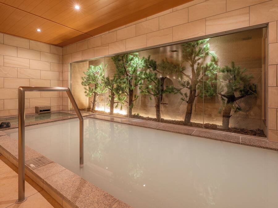 A spa area with a glass wall, a wooden ceiling, and a metal railing.